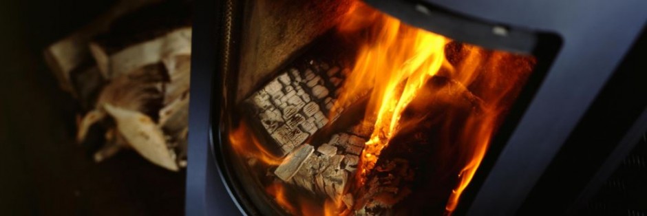 A wood fire burning behind a stove’s glass-ceramic viewing panel