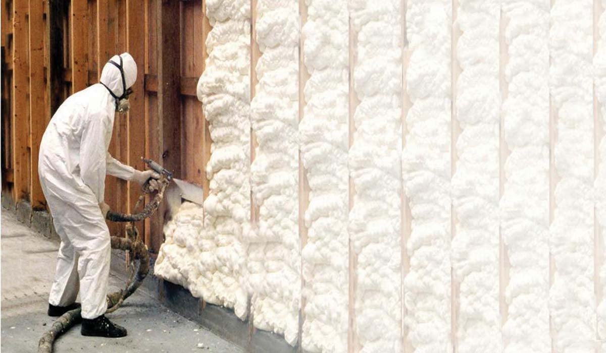 Technician spraying cellulose foam insulation in an attic